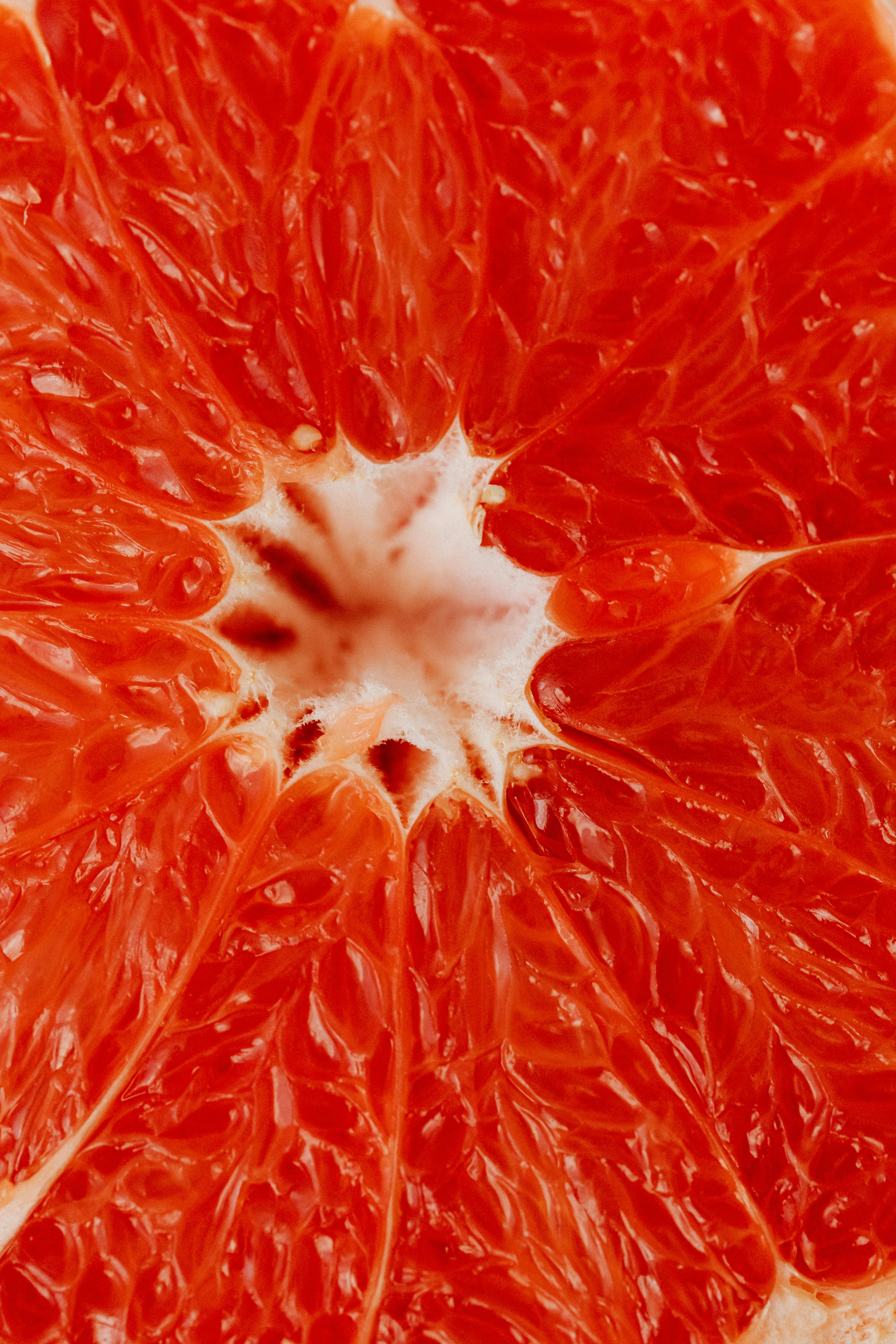 Detailed macro shot of a vibrant grapefruit with visible juice vesicles.