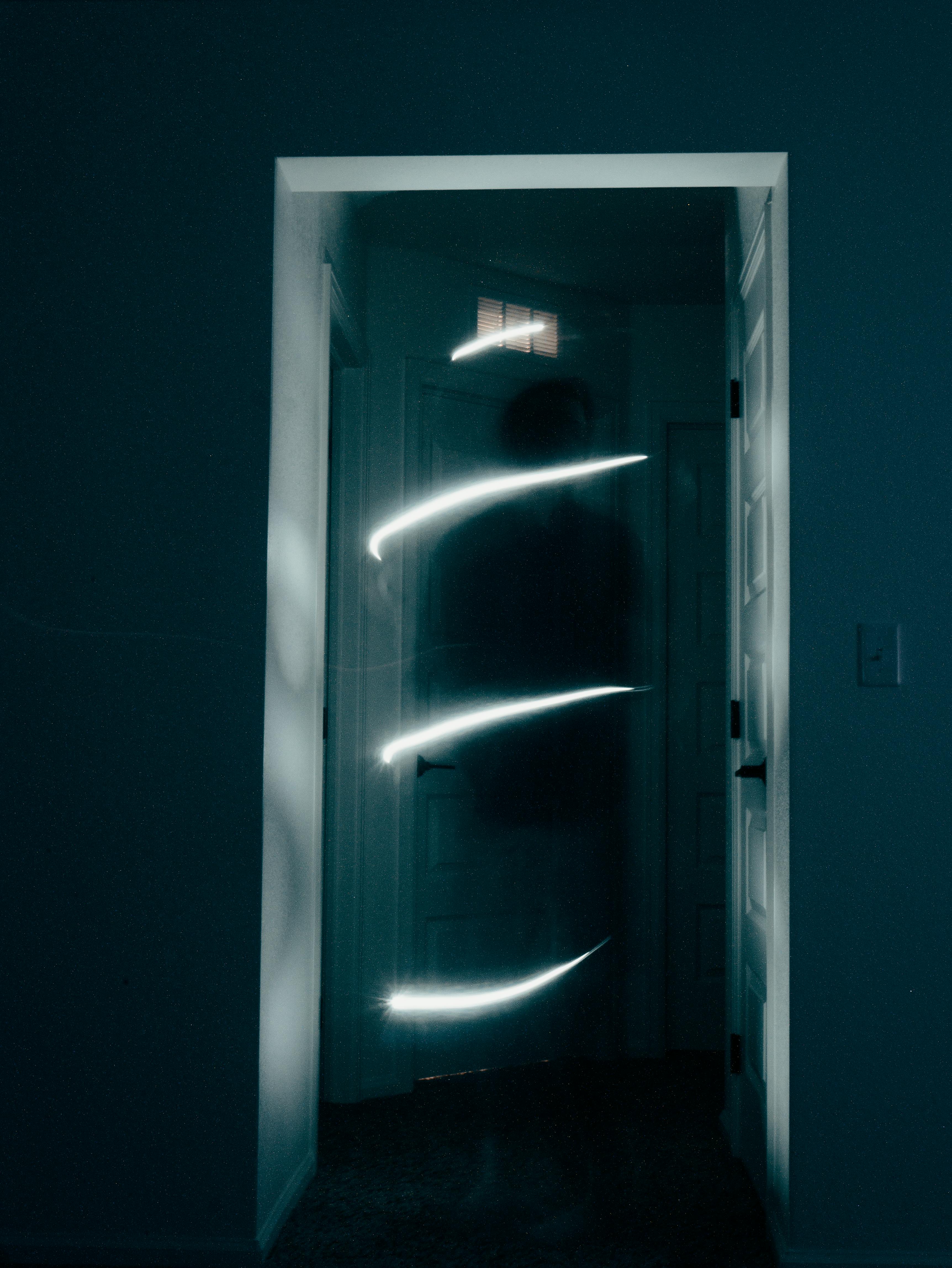 Mysterious hallway illuminated by swirling light, creating a ghostly ambiance.
