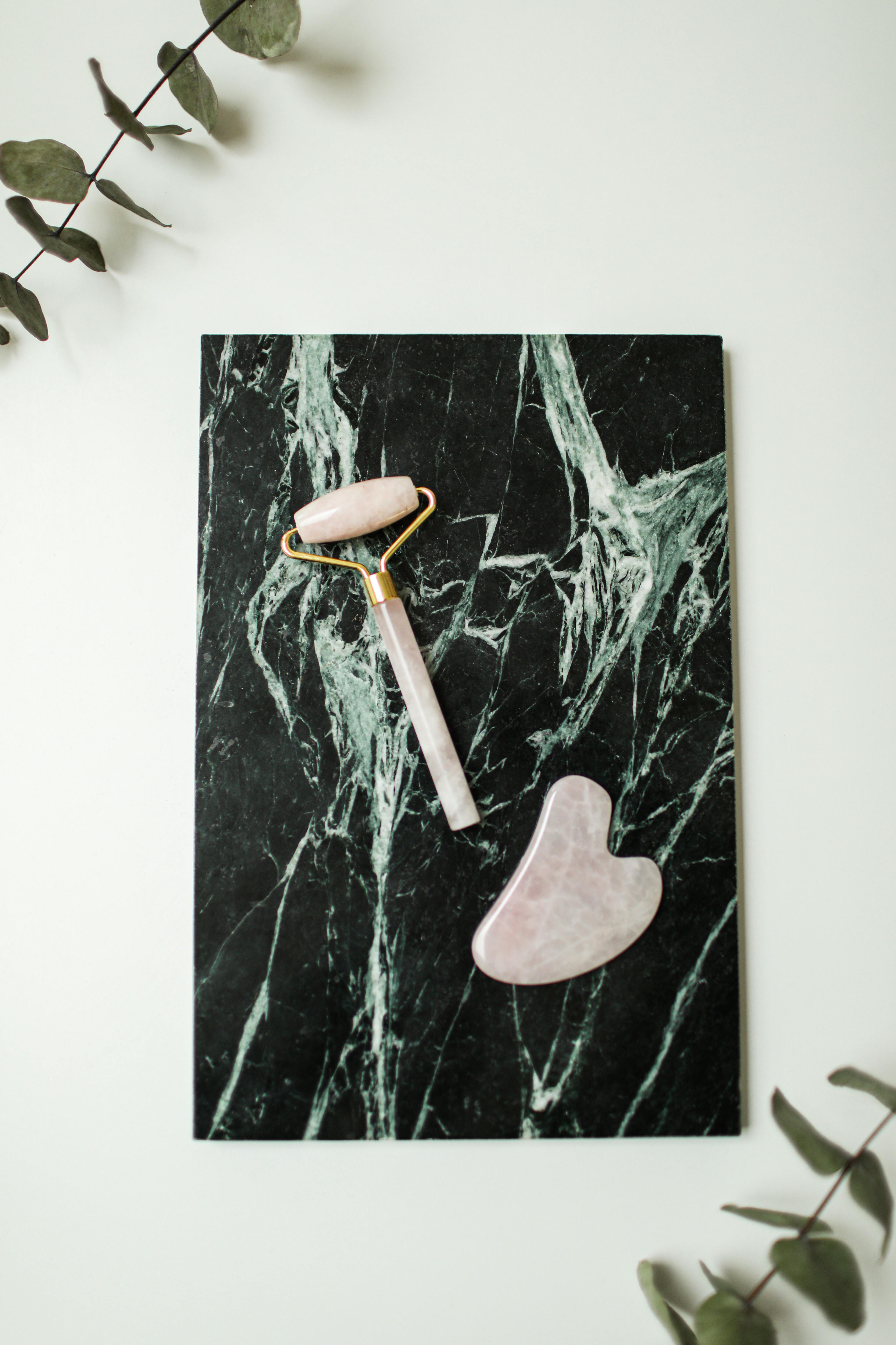 Beauty tools on dark marble background, ideal for skincare and wellness themes.