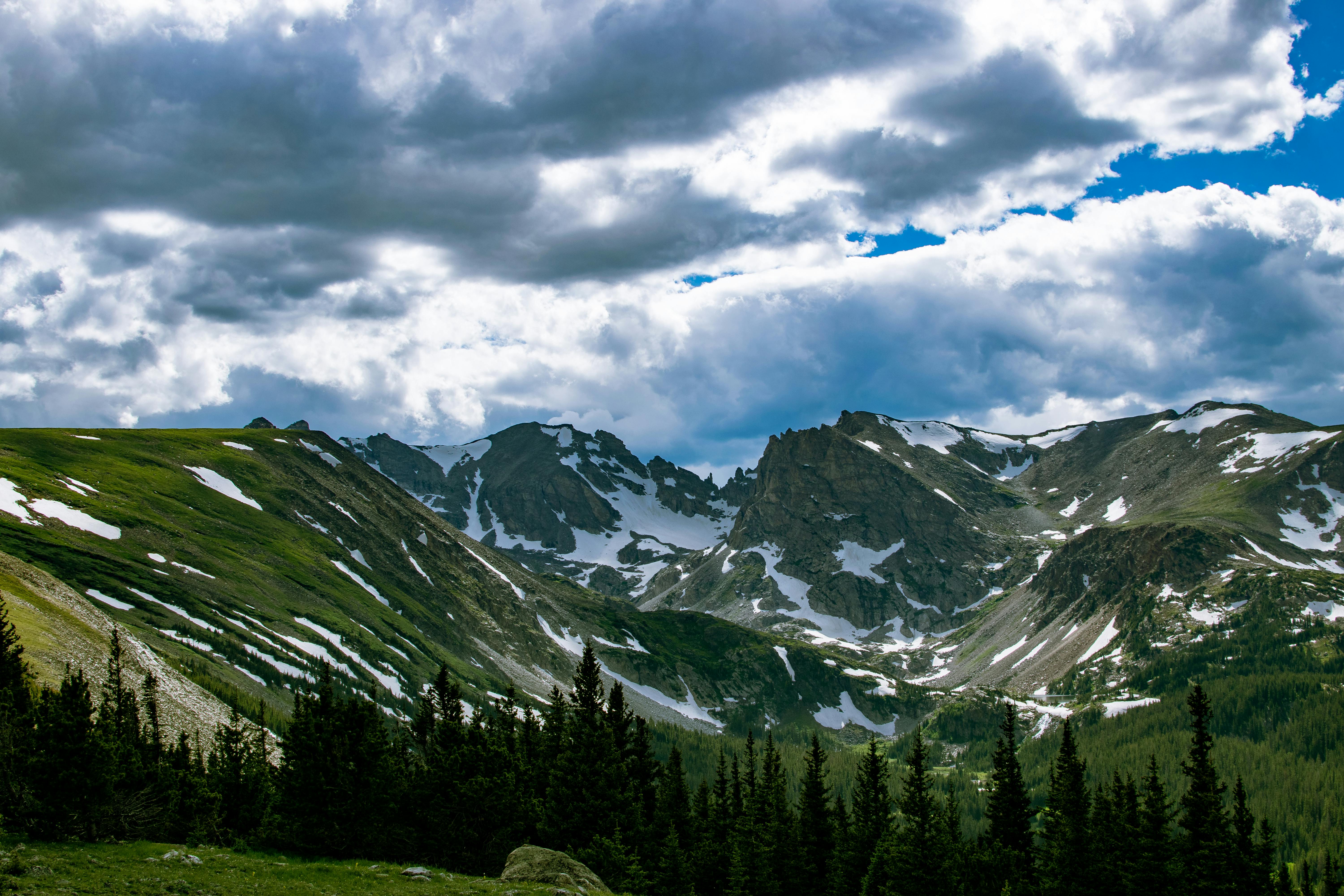 Breathtaking view of snow-capped mountains under dramatic clouds in Denver, Colorado.