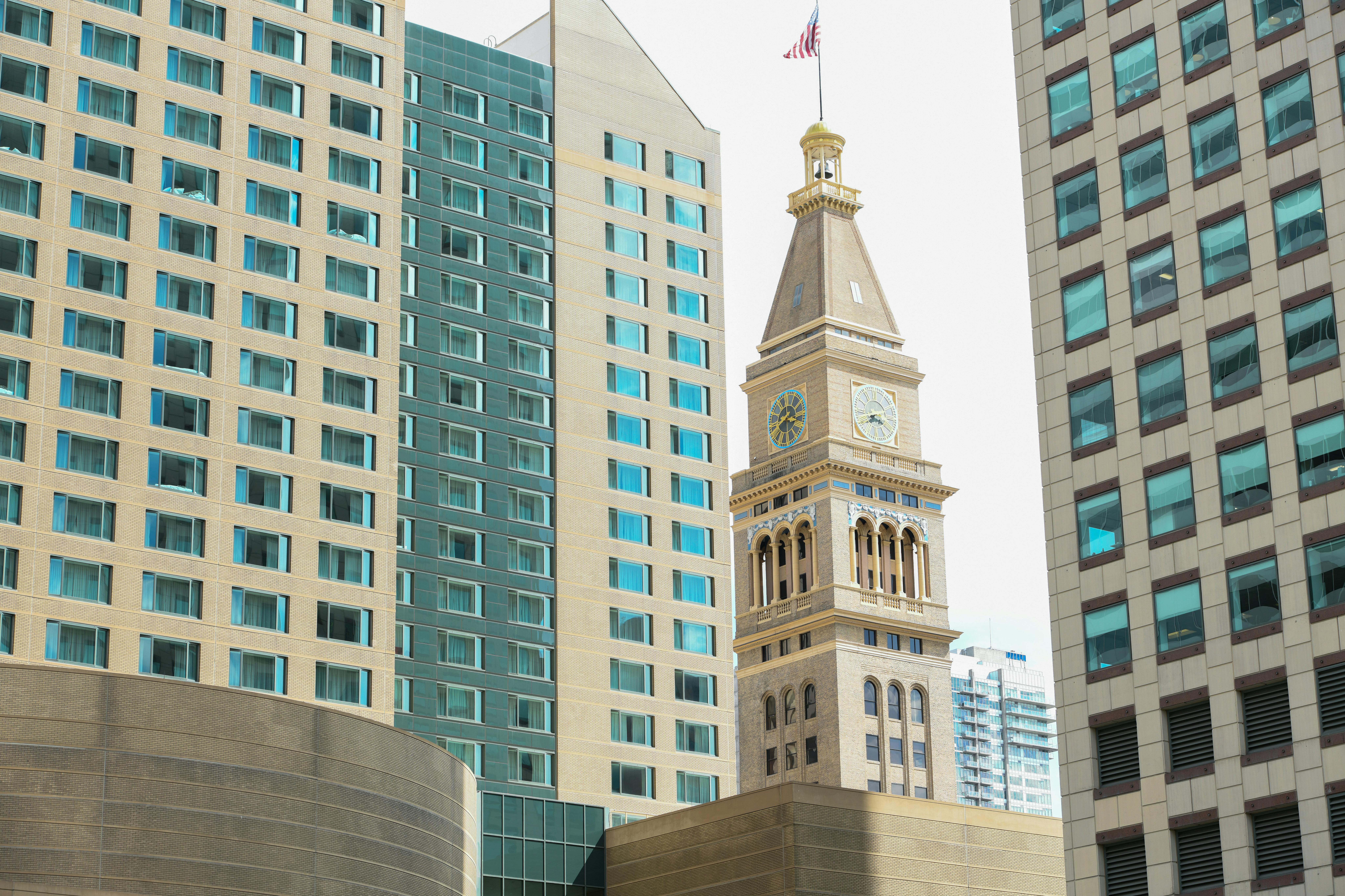 Iconic Daniels & Fisher Tower flanked by modern skyscrapers in Denver's cityscape.