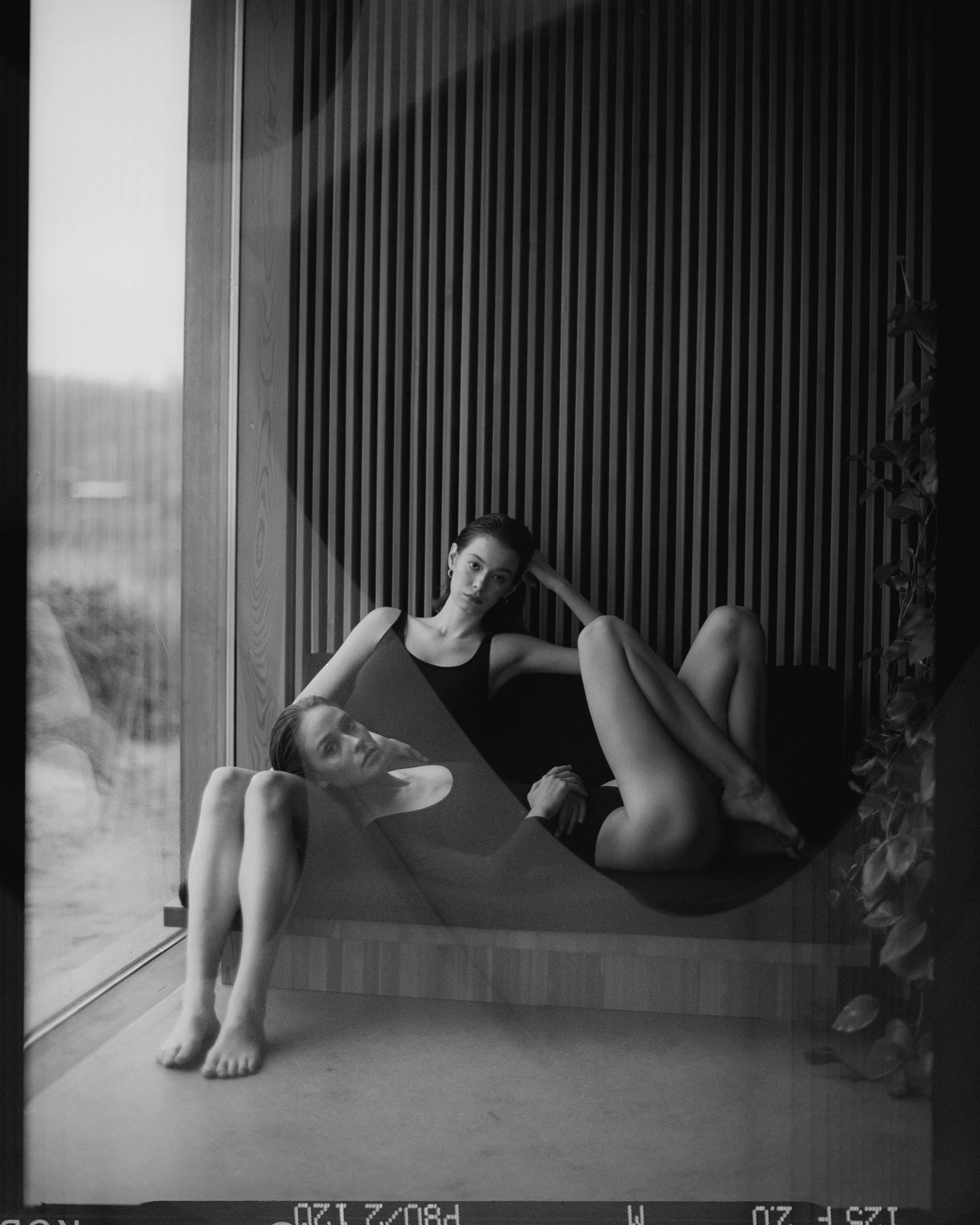 Monochrome image of two women relaxing indoors, creating a serene and intimate atmosphere.
