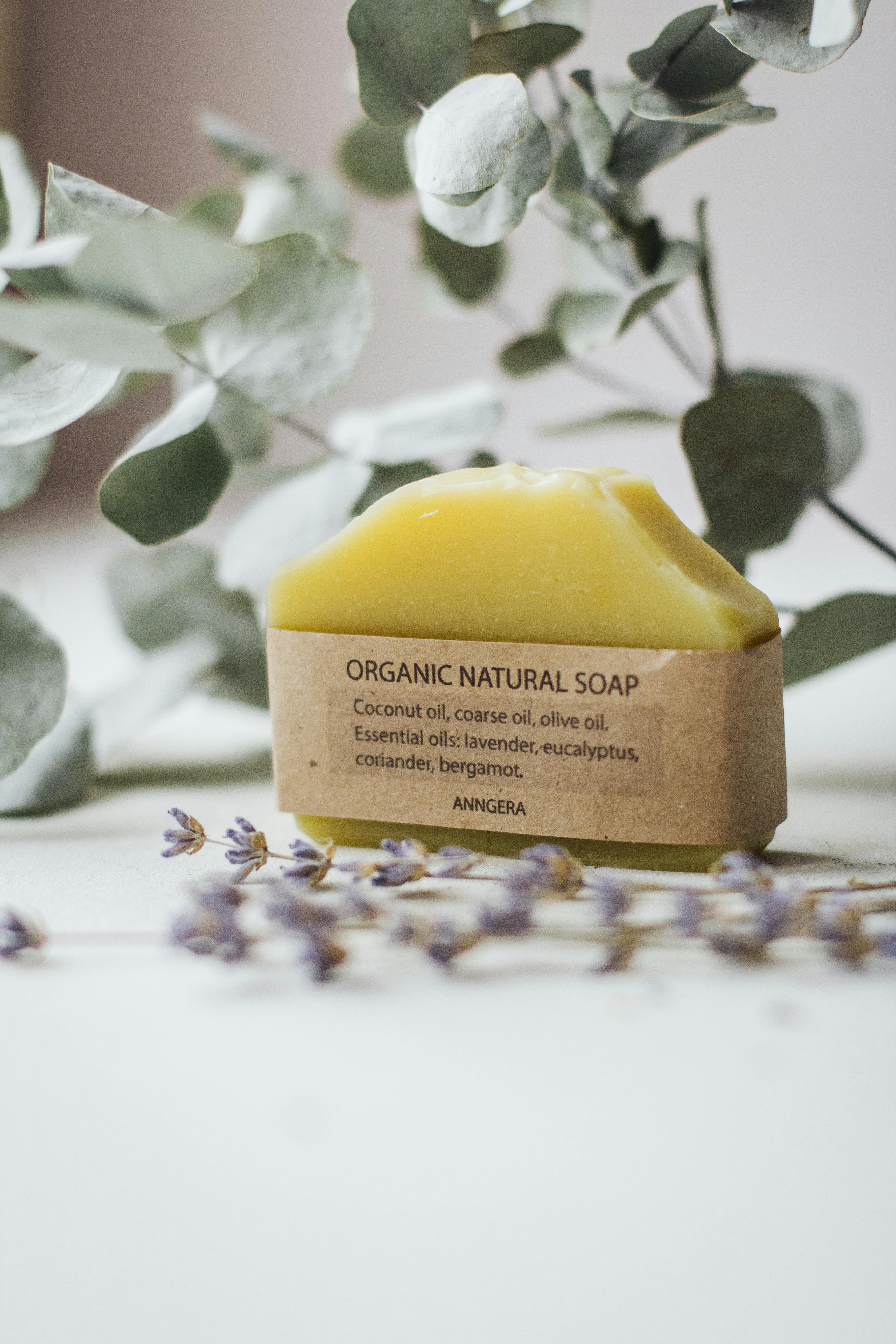 Organic soap with eucalyptus and essential oils against a blurred botanical background.