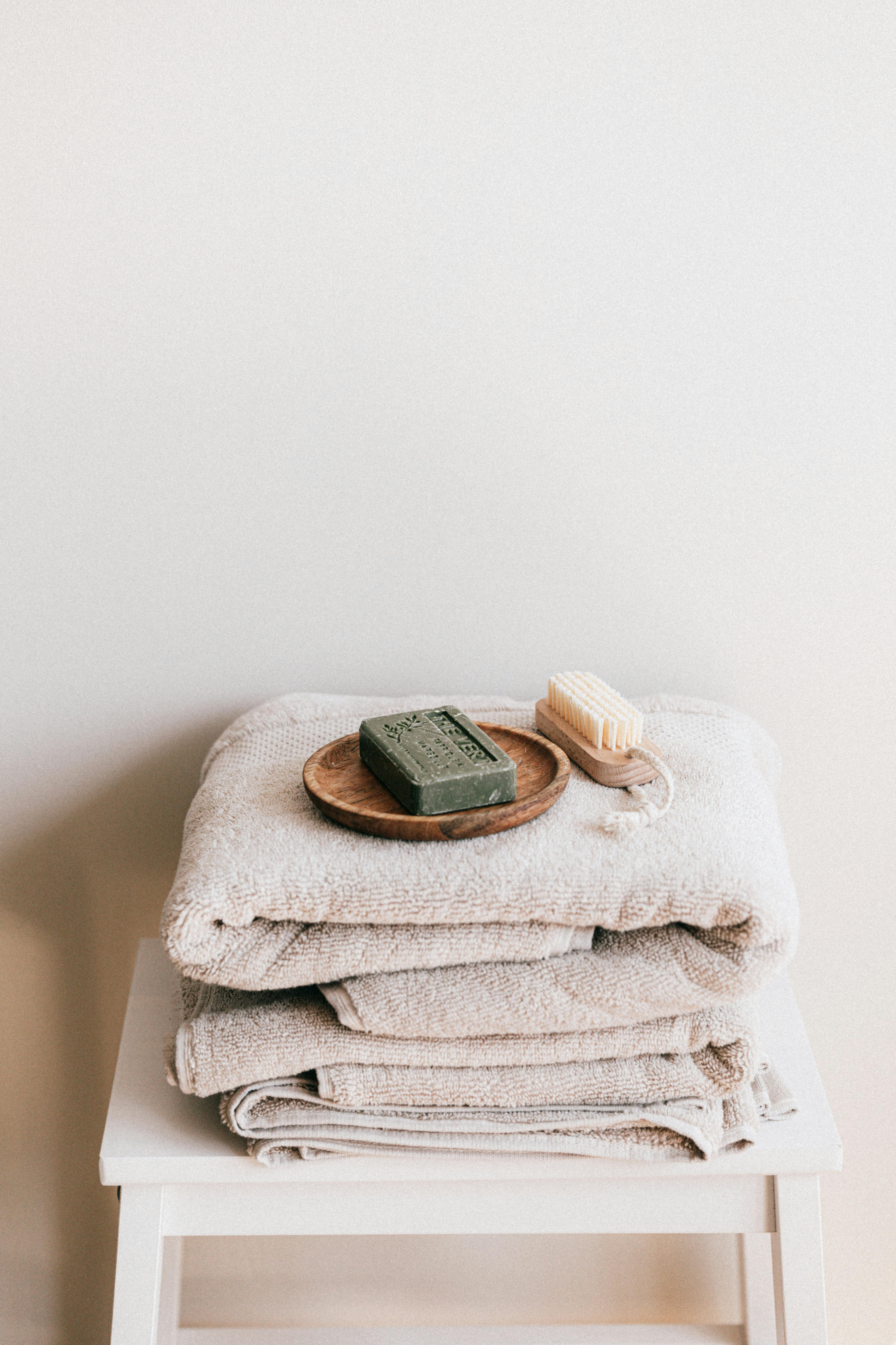 Elegant stacked towels with soap and brush create a calming bathroom vibe.
