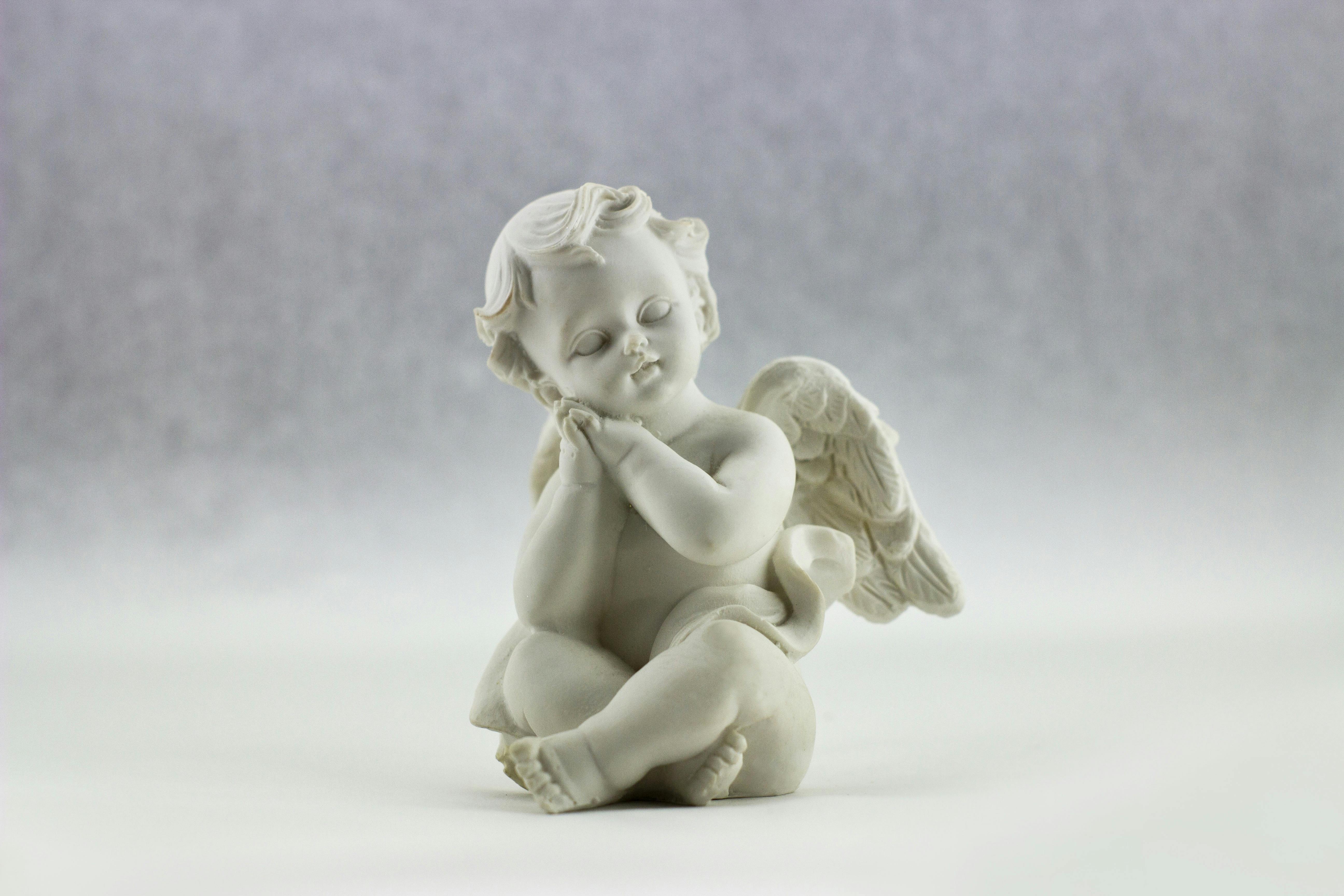 A cute ceramic angel figurine in a serene pose, perfect for decorative art displays.