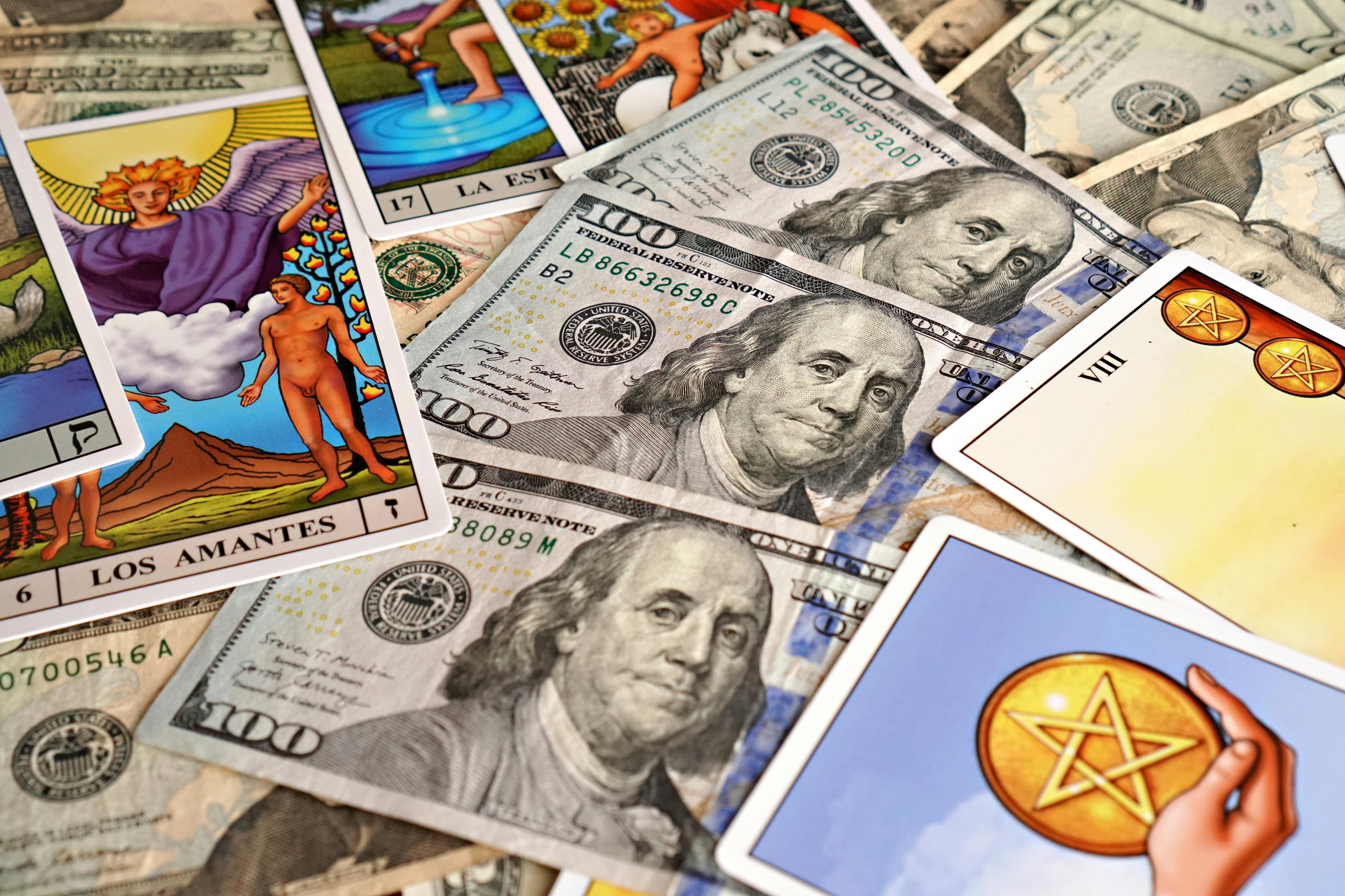 Tarot cards placed on US currency represent wealth and fortune concepts.
