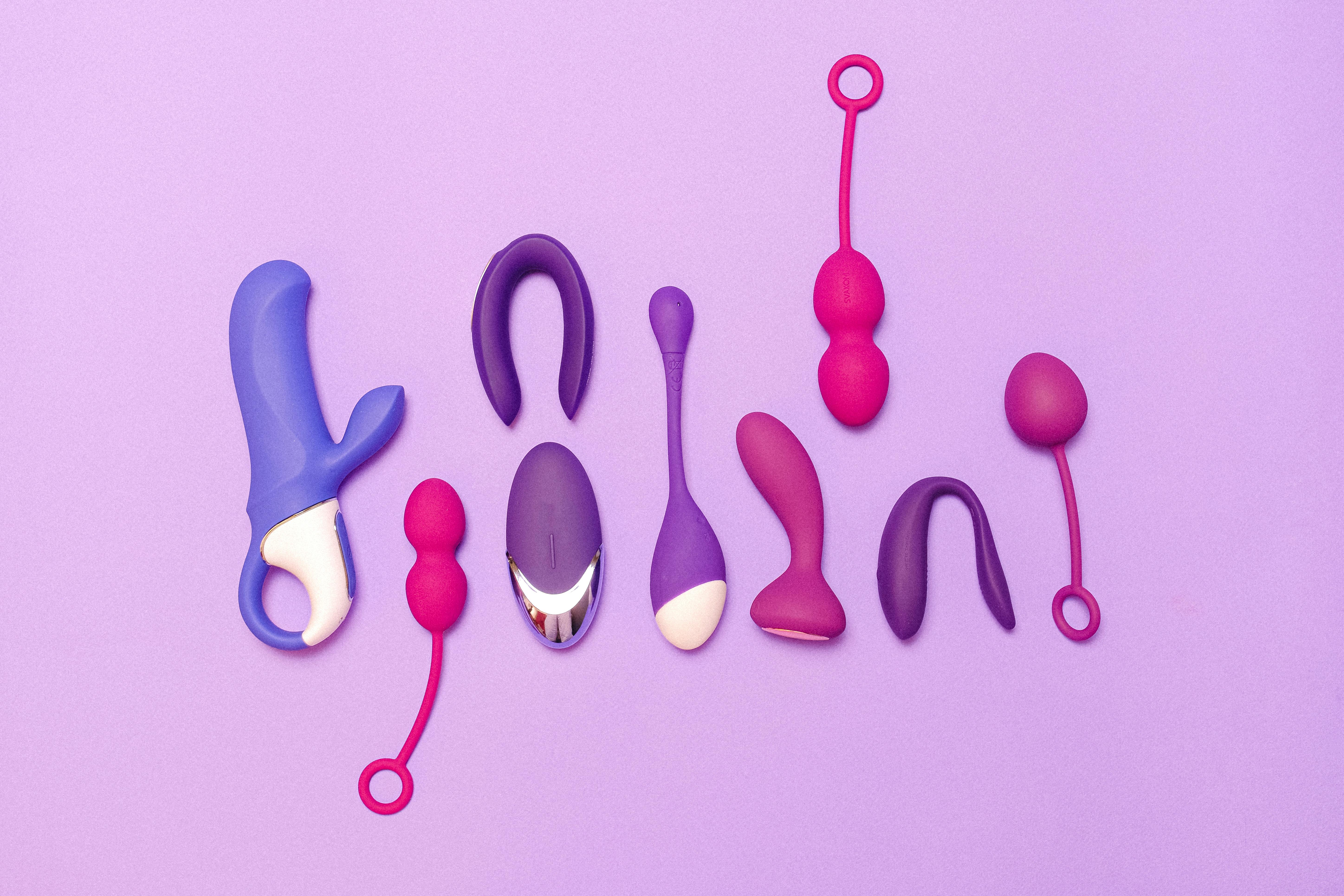 Various silicone sex toys displayed on a purple background for pleasure and education.