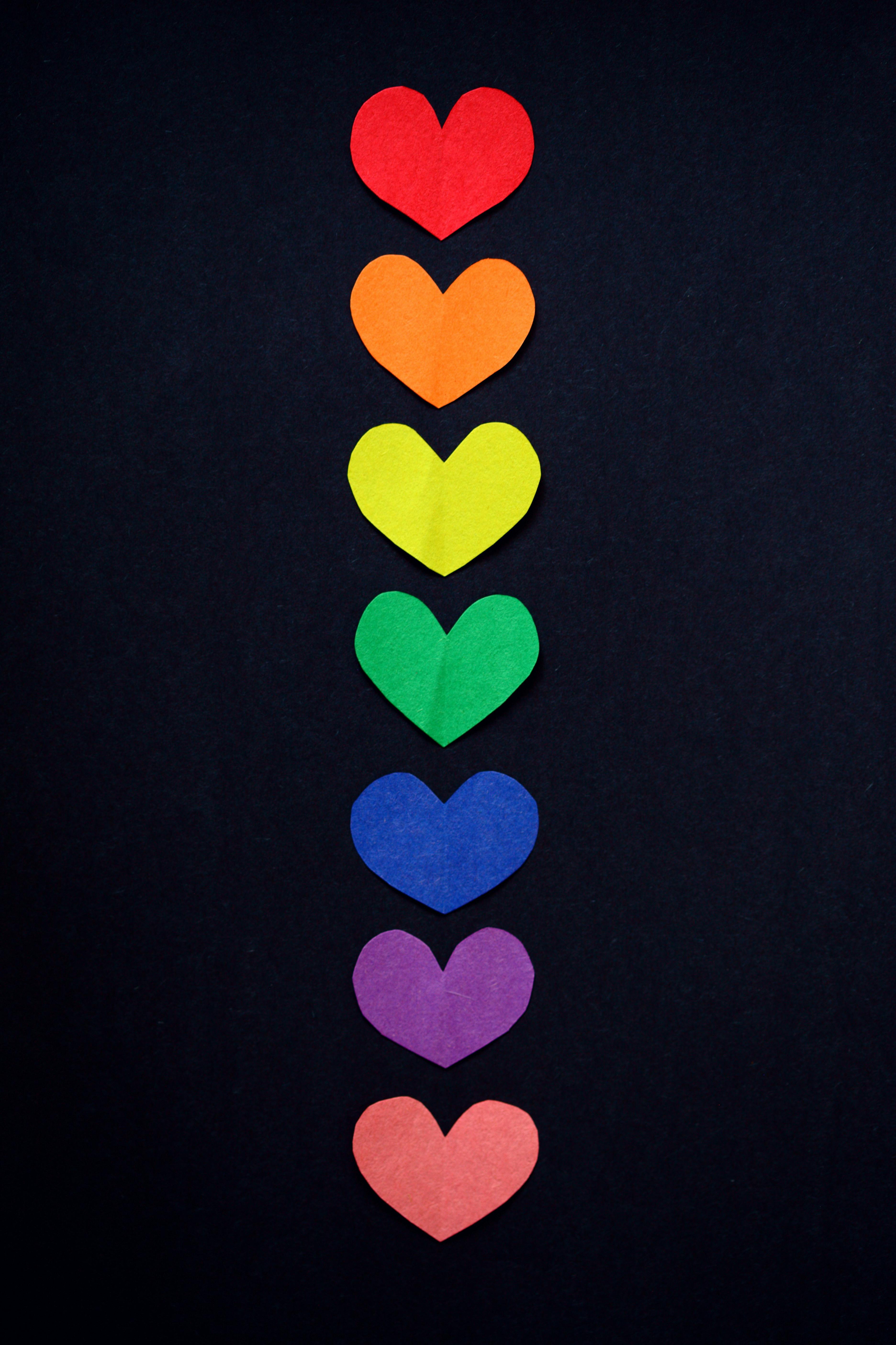 Colorful rainbow hearts arranged vertically symbolizing love and diversity.